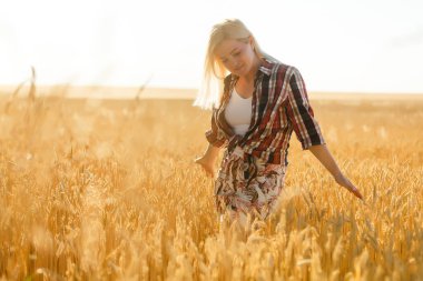 Buğday dikenlerinin ortasında bir kız. Kafkasyalı kadın dikenli çubuklarla dışarıda poz veriyor..