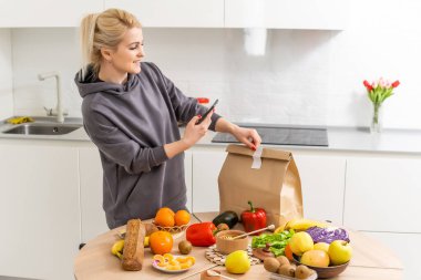 Kadınlar mutfaktaki alışverişleri halleder. Kese kağıdında market teslimatı. Coronavirus COVID19 nedeniyle karantina koşullarında marketten abonelik hizmeti