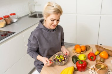 Güzel genç bayan mutfakta sebze salatası hazırlıyor. Evde Pişirme