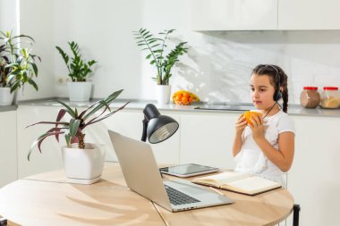 Küçük kız Studen evde dizüstü bilgisayarla online ders çalışıyor. Covid-19 koronavirüs. Sosyal uzaklık, evde eğitim..