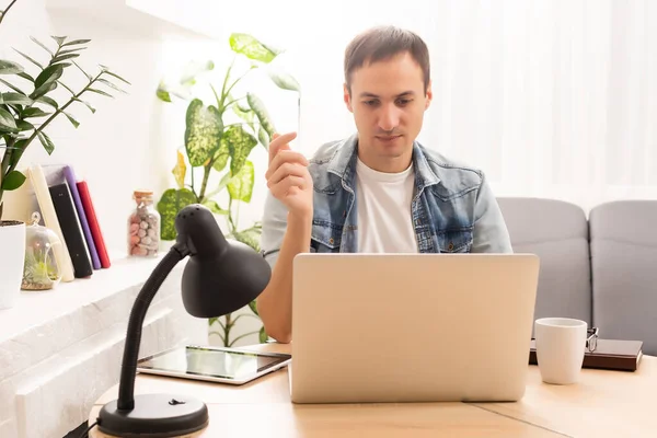 technology, remote job and lifestyle concept - happy man with laptop computer having video chat and waving hand at home office