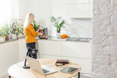 Evde çalışmak - bir dizüstü bilgisayar ve arka planda mutfak masası olan bir organizatör..