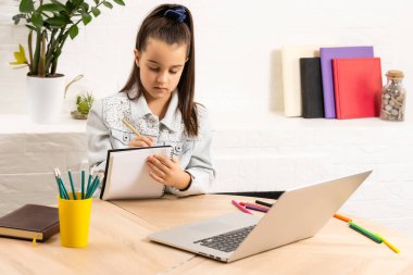 Öğrenci küçük kız ödevi dizüstü bilgisayarda gümüş