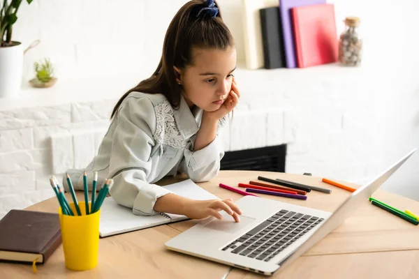 children, education and distant learning concept, little student girl with laptop computer at home