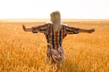 Buğday dikenlerinin ortasında bir kız. Kafkasyalı kadın dikenli çubuklarla dışarıda poz veriyor..
