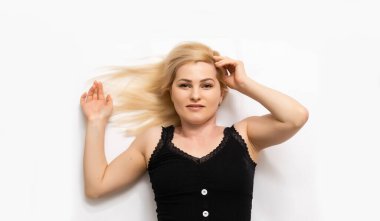 Yerde yatan genç ve güzel bir kadın, beyaz tenli.