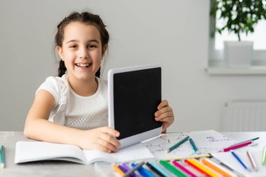 Eğitim ve okul konsepti. Okulda bir sürü kitabı olan gülümseyen küçük kız öğrenci.