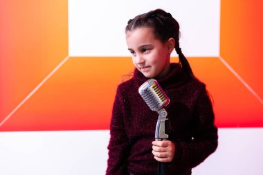 Regording stüdyosu. Şarkı söyleyen ya da rol yapan kız çocuğu