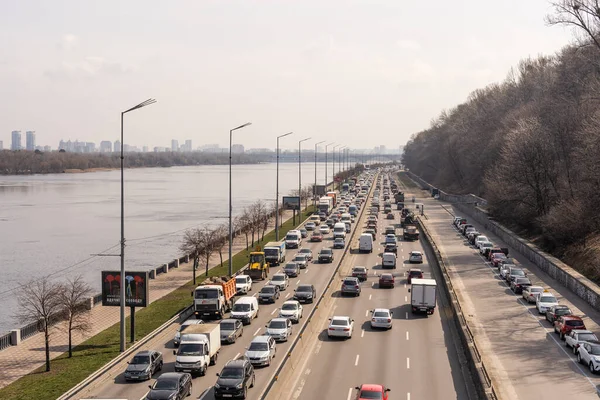 Kyiv, Ukraine- April 1, 2021: Automobile collapse at the highway along Dnipro River. Traffic jam with rows of cars on motorway in the week-end day in Kyiv. Concept of traffic jams in the big city. — Stock Photo, Image