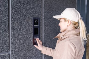 Kadın elini kapat ve kapı düğmesine bas. Kız dahili telefonu arıyor. İletişim araçları ya da varış ve güvenlik girişleri