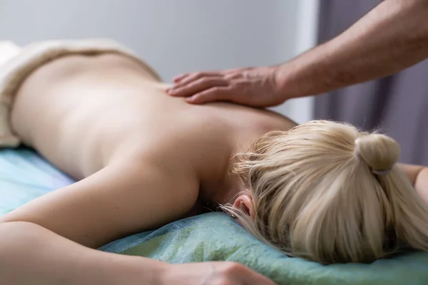 Massage en lichaamsverzorging. Therapeutische spa lichaamsmassage. Vrouw liggend en ontspannend bij massage in een gezellige huiselijke omgeving. vrouw met massage — Stockfoto