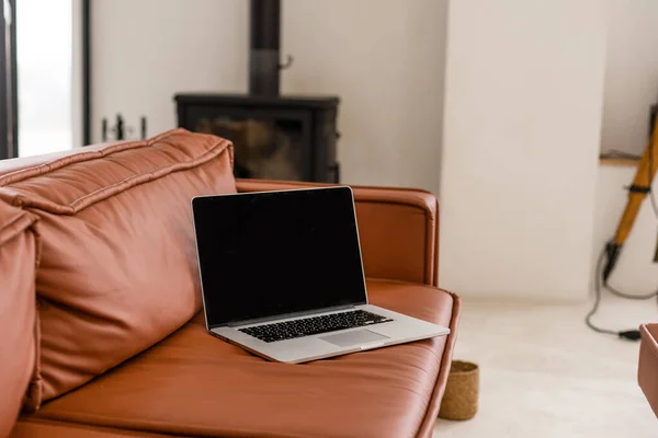 Laptop z pustym ekranem na sofie w salonie — Zdjęcie stockowe