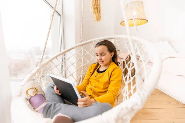Leuk meisje liggend op de bank met tablet computer — Stockfoto
