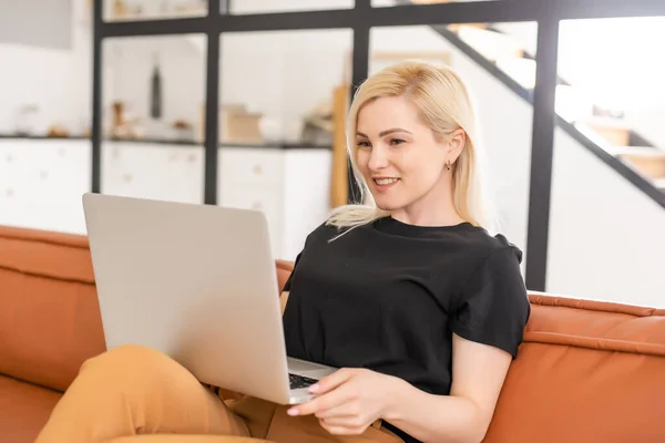 Happy casual piękna kobieta pracuje na laptopie siedzi w domu. — Zdjęcie stockowe