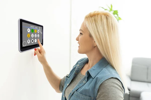 Frau benutzt Tablet in Wand Smart House — Stockfoto