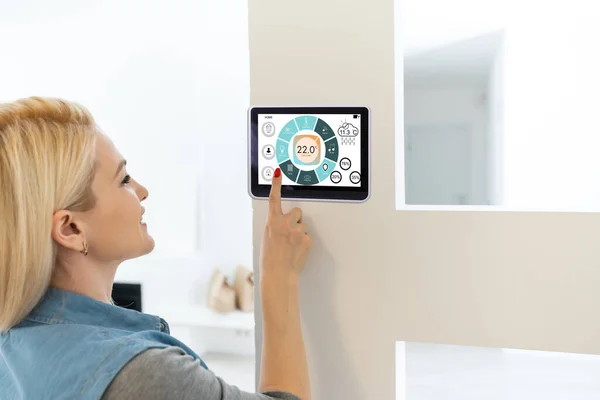 Умный дом цифровой термостат сенсорный экран женщина трогает сенсорный экран, чтобы регулировать температуру отопления в стене гостиной — стоковое фото