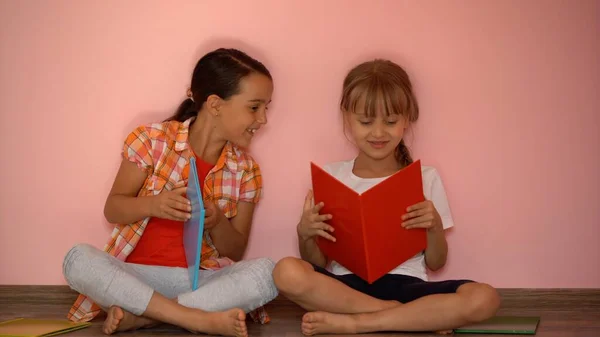 Onderwijs en school concept - kleine studenten meisjes studeren en lezen boek thuis — Stockfoto