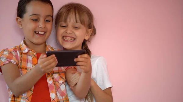 Dos niñas tomando fotos con un smartphone — Foto de Stock