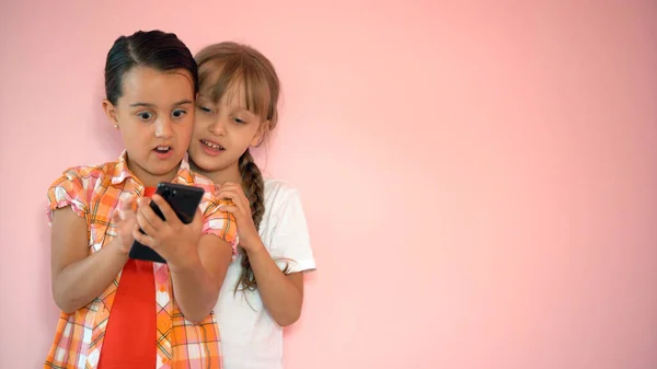 Las niñas felices con un teléfono inteligente en las manos se comunican en casa con sus seres queridos utilizando la tecnología moderna — Foto de Stock