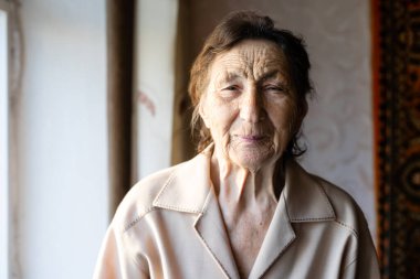 Güzel, yaşlı bir kadının yanında, pencerenin yanında.