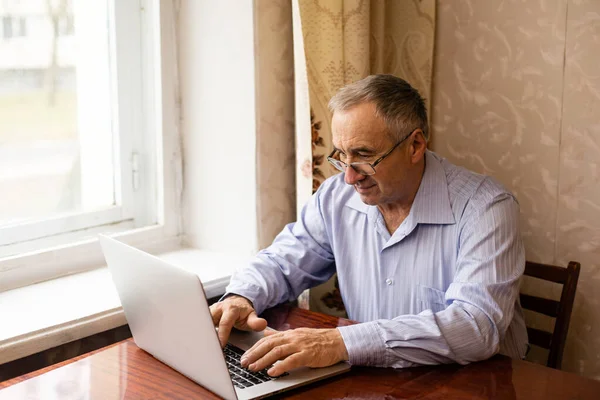 Video conferenza uomo anziano sul computer portatile sopra scrivania di legno — Foto Stock