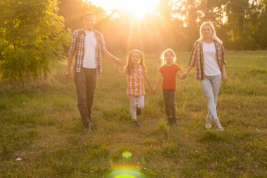 Doğada gün batımında mutlu bir aile