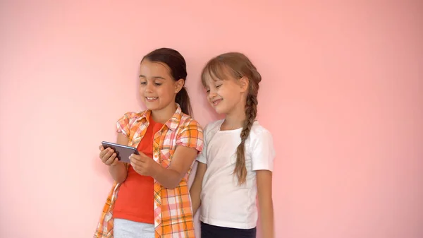 Ludzie, dzieci, technologia, przyjaciele i koncepcja przyjaźni - szczęśliwe dziewczynki ze smartfonami siedzące na kanapie w domu — Zdjęcie stockowe