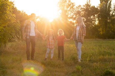 Doğada gün batımında mutlu bir aile