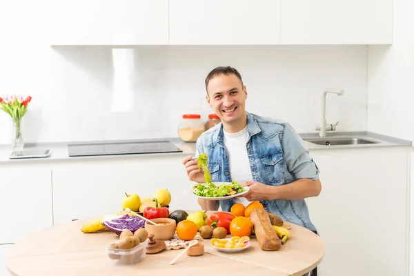 Jongeman die een gezonde salade eet, groenten, gezond voedsel. — Stockfoto