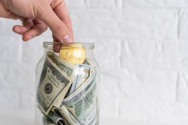 El cam kavanoza bir bitcoin koyar gerçek para arkaplan arasında. Kripto para birikimi, tasarruf, yatırım, risk kavramı