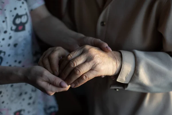 Oigenkännlig mormor och hennes barnbarn håller varandra i handen. — Stockfoto