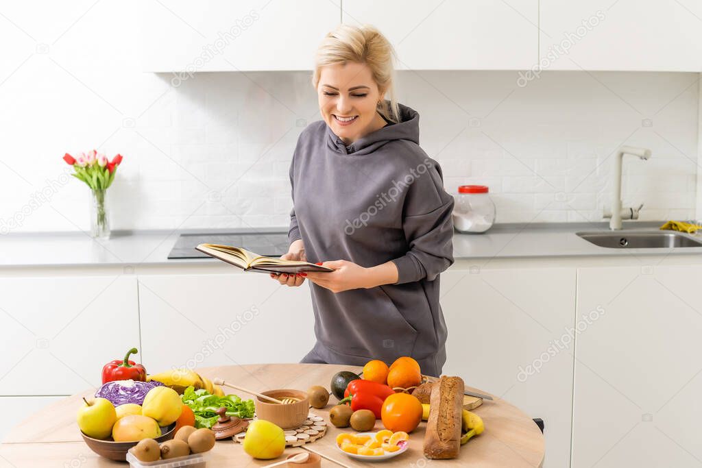 Fresh healthy green vegetables and fruits on wooden table, dieting, fitness and active healthy lifestyles concept. woman with notepad