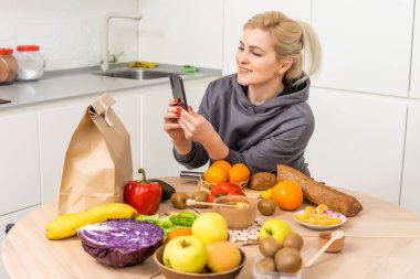 Kadınlar mutfaktaki alışverişleri halleder. Kese kağıdında market teslimatı. Coronavirus COVID19 nedeniyle karantina koşullarında marketten abonelik hizmeti