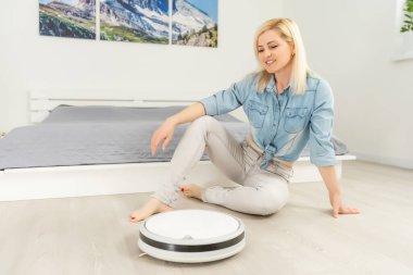 Robotik süpürge lamine ahşap zemin üzerinde çalışıyor.