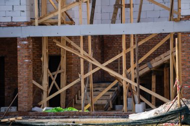 İnşaat alanındaki büyük pencereli beyaz bloklardan yapılmış bina cephesi