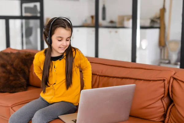 Dítě online. Malá holka používá notebook video chat komunikovat učení při sezení u notebooku doma — Stock fotografie