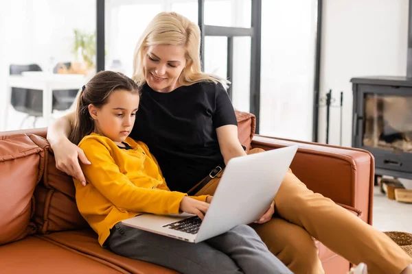 집에서아이와 함께 일하고 있어요. 행복 한 엄마와 딸 이 노트북을 사용하여 온라인 쇼핑을 하고 있습니다. 아이를 안고 있는 여자. 프리랜서 직장. 여성 사업, 가상 의사소통. — 스톡 사진