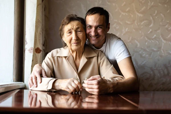 Eine sehr alte Frau und ein erwachsener Enkel — Stockfoto