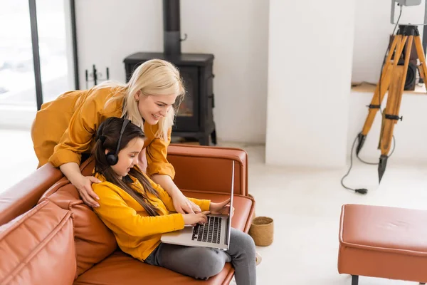 Mãe e filha adolescente olhando para laptop juntos — Fotografia de Stock