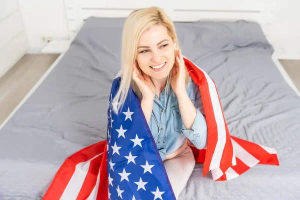 Femme à l'écoute Cours d'anglais Livre audio devant le drapeau américain — Photo