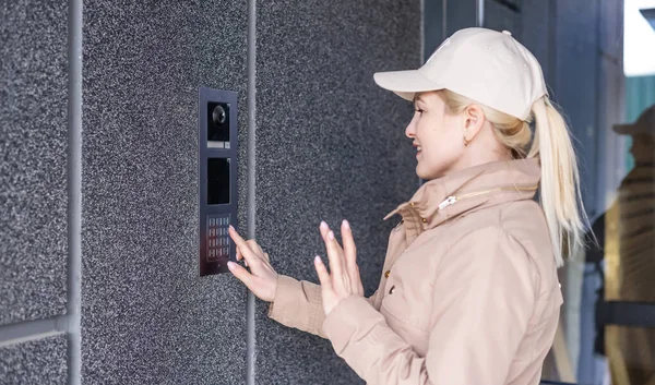 Cierre la mano femenina presiona el botón de la puerta. La chica está llamando al intercomunicador. Medios de comunicación o notificación de llegada y seguridad de la entrada interior —  Fotos de Stock