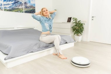 Robotik süpürge lamine ahşap zemin üzerinde çalışıyor.