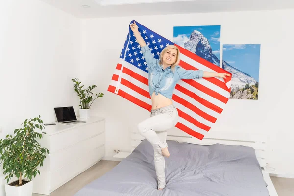 흰색 배경에 미국 국기를 두른 웃는 여자의 모습 — 스톡 사진