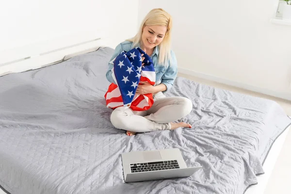 미국 소녀가 노트북으로 스트리밍을 하고 있습니다. 미국 국기 가 뒤에 있습니다. 브 러거 개념. — 스톡 사진