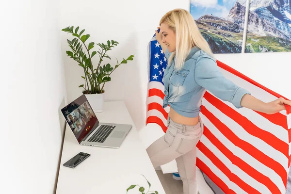 Mulher segurando bandeira dos EUA e vídeo por laptop — Fotografia de Stock