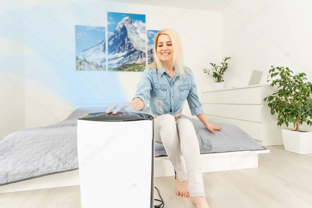 woman turns on the air purifier