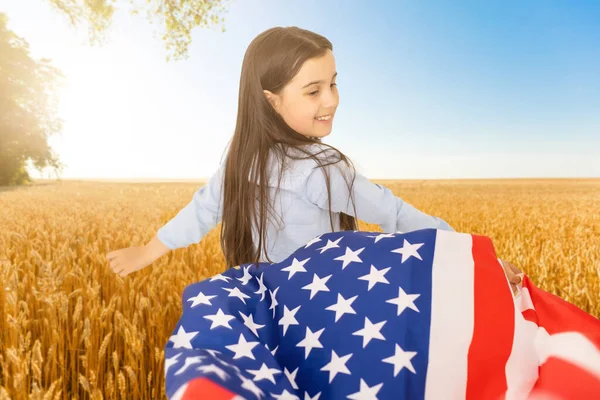Bandera americana. Pequeña chica feliz patriótica corriendo con bandera americana ondeando sobre el fondo de la naturaleza al aire libre. EE.UU. celebra el 4 de julio. —  Fotos de Stock