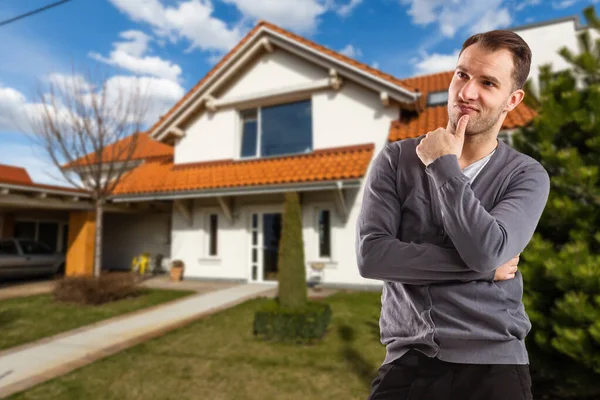 Веселый мужчина стоит перед новым домом — стоковое фото