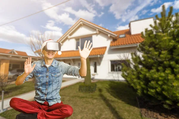Wesoły człowiek w wirtualnych okularach przed nowym domem — Zdjęcie stockowe