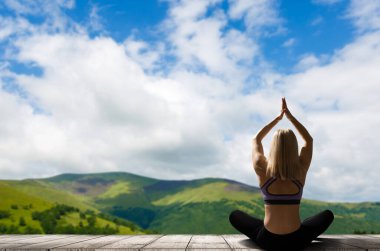 Yoga yapan genç bir kadın. Kadın mutluluğu. Peyzaj arkaplanı